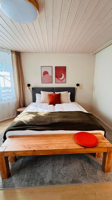 a bedroom with a large bed with a wooden table at 130sqm Duplex with AirC - Gratis Parking - Familie Freunde - See und Jura in Biel