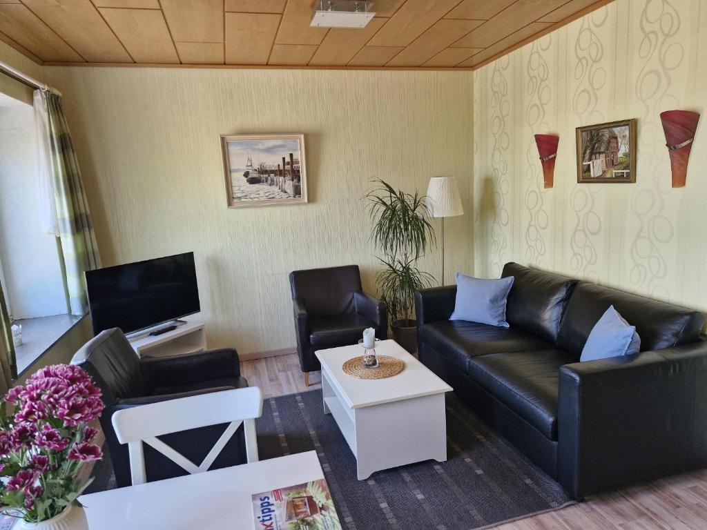 a living room with a couch and a tv at Haus Schildt, FeWo 2 in Duhnen