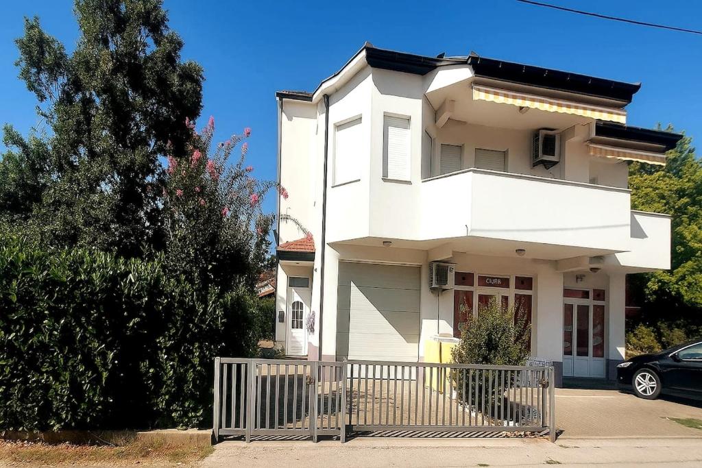 a white house with a fence in front of it at Ruža Vacation House in Međugorje