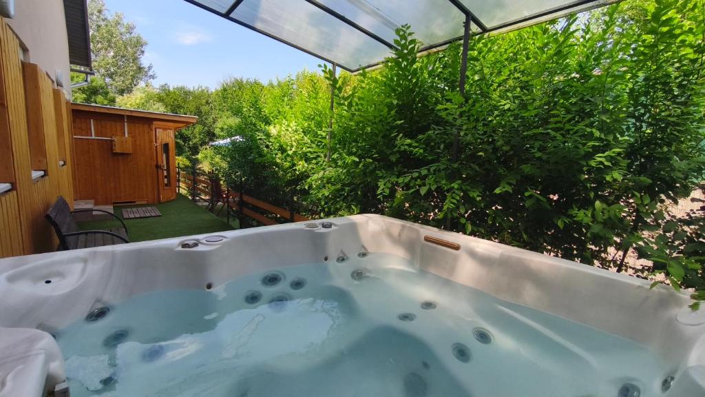 a jacuzzi tub in the backyard of a house at Rigófészek Apartmanház in Gárdony