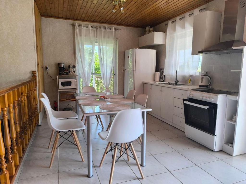 a kitchen with a table and chairs in a kitchen at Afroditi Country Residence in Oropos