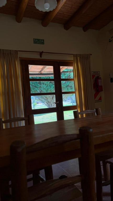a dining room with a table and a large window at Complejo Don Antonio in San Agustín de Valle Fértil