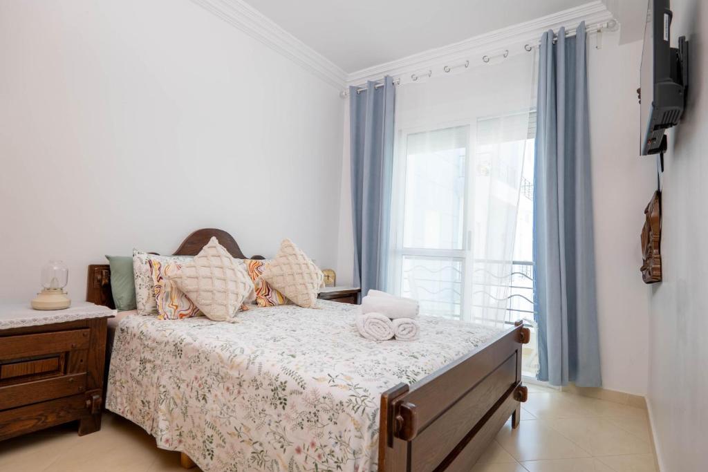 a bedroom with a bed with pillows and a window at Apartamento de lujo Martil in Martil