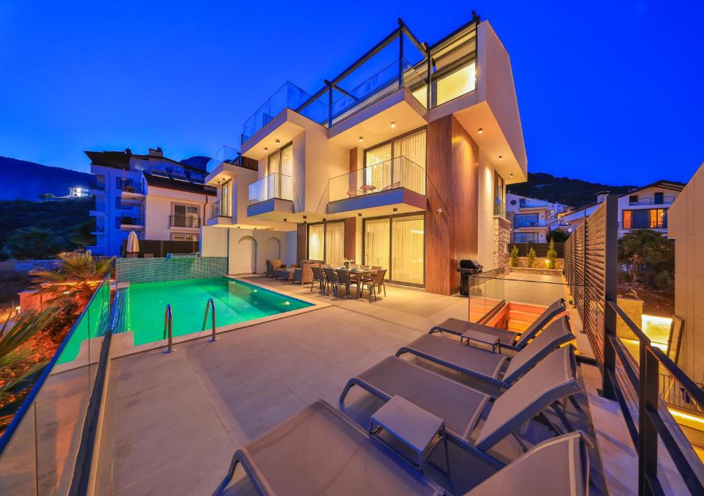 a house with a swimming pool and some chairs at Villa Infinity Sky - Private Pool - Panoramic Sea View in Kaş