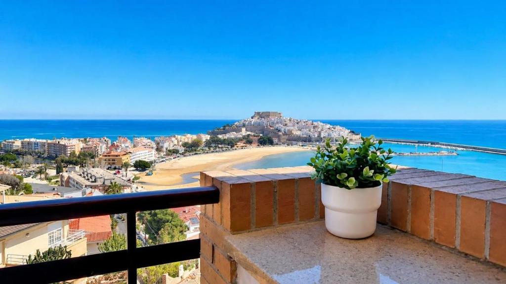 a view of a beach from a balcony with a plant at Marina suite in Peniscola