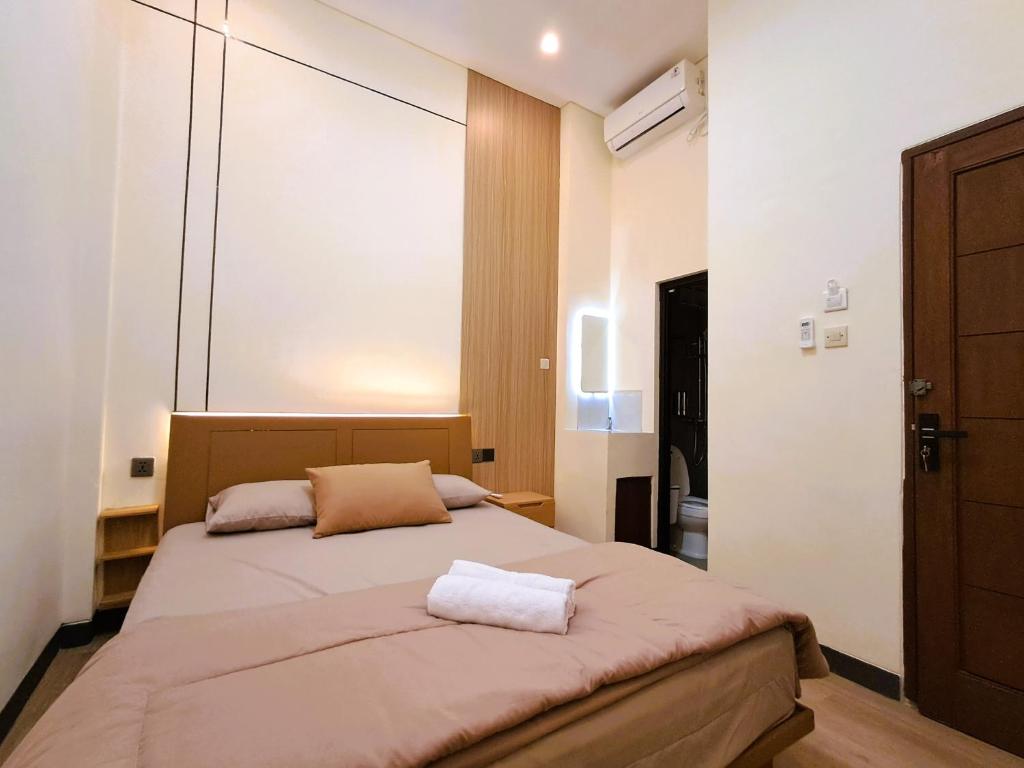a bedroom with a bed with a large window at Nafaka Hostel and Tours in Malang