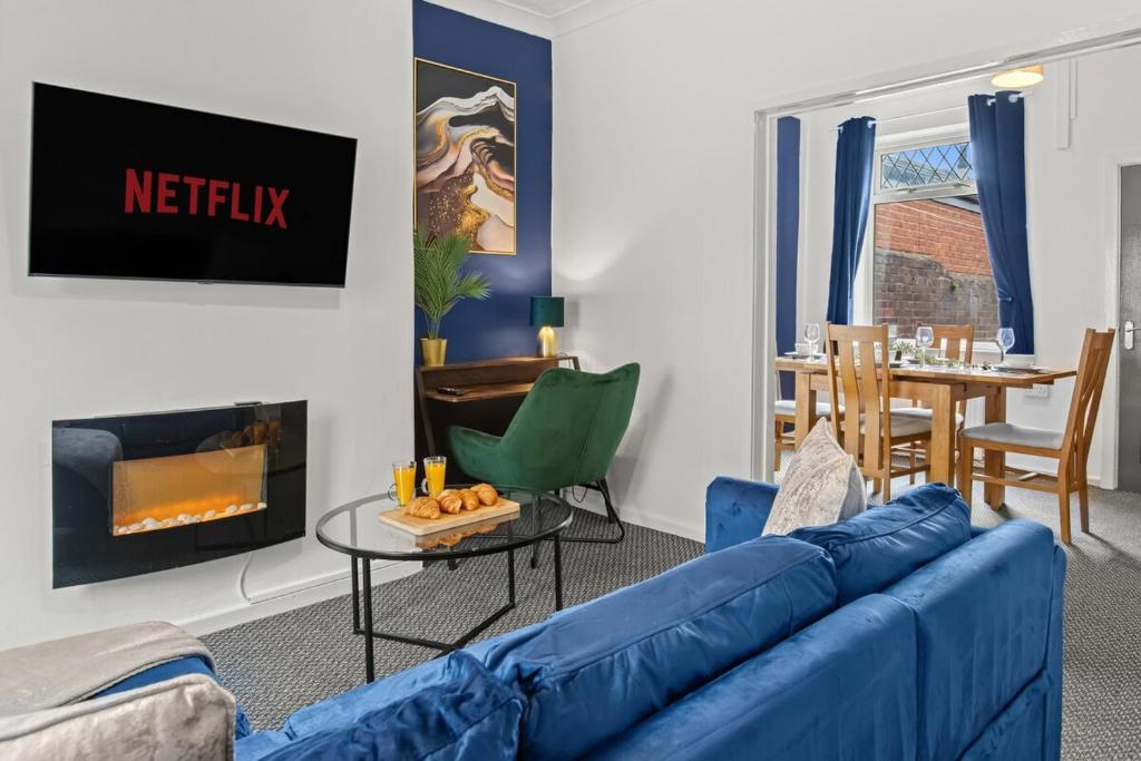 a living room with a blue couch and a table at Haydock Contractor House, 2-Bed, Easy M6 Access in Haydock