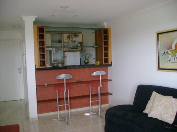 una sala de estar con un bar con taburetes y un sofá en Victory Flat Intermares en Cabedelo