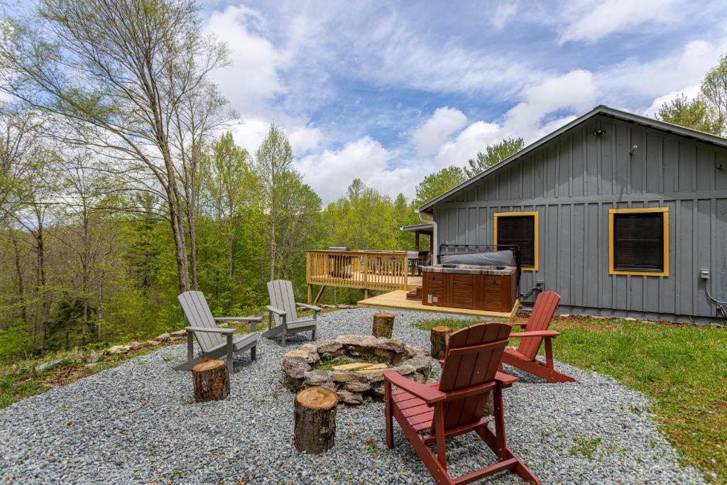 a backyard with chairs and a fire pit and a cabin at Deer Valley in Elk Park