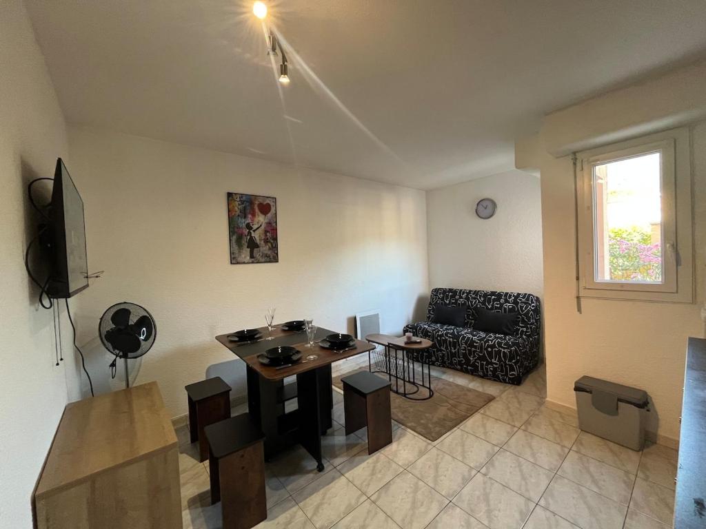 a living room with a couch and a table at Studio avec piscine à 1km de la plage in Cavalaire-sur-Mer
