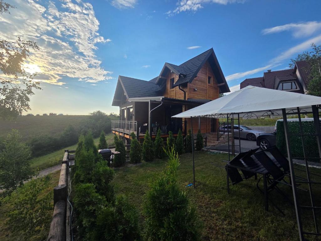 a house with a white umbrella in front of it at LUX PINE house in Zlatibor
