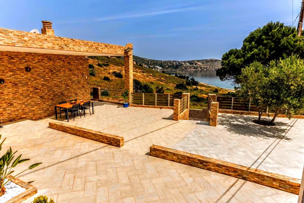 a patio with a table and a brick building at VillaAnna in Keratea