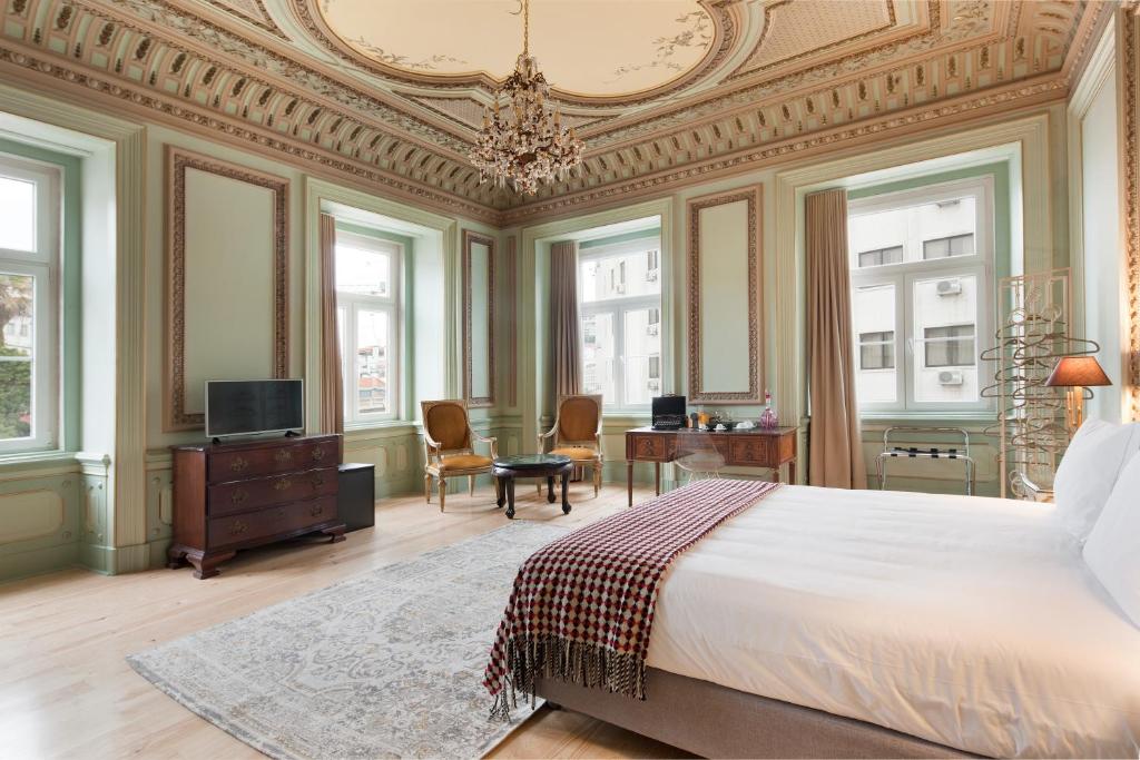 里斯本的住宿－希爾都特索大巴薩旅館，一间卧室配有一张大床和一个吊灯。