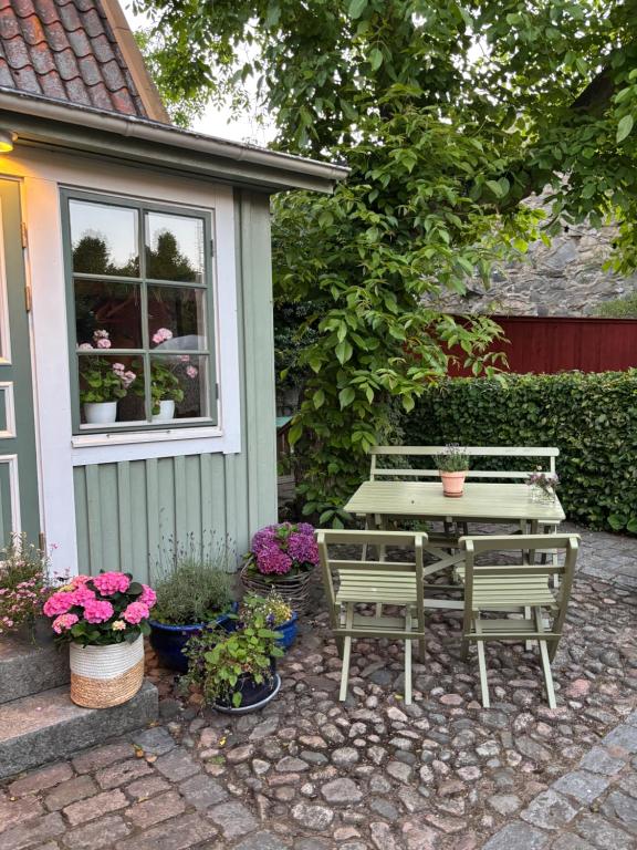 a patio with a table and two benches and flowers at Hannas hus in Karlskrona