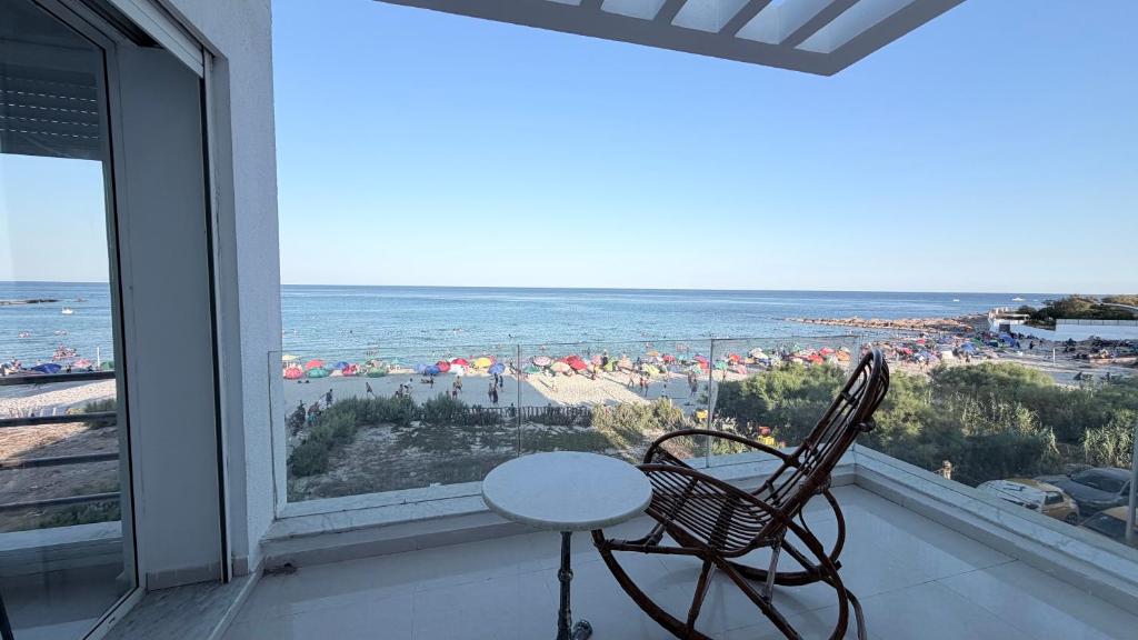 a table and chairs on a balcony with a view of the beach at Le paradis 210 in Kelibia