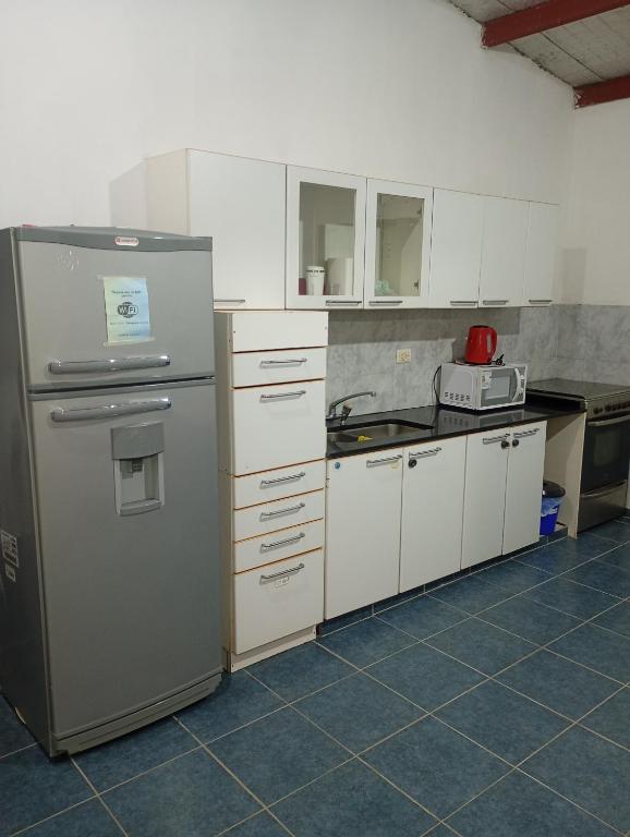 a kitchen with white cabinets and a stainless steel refrigerator at La Tranquila in Fernández