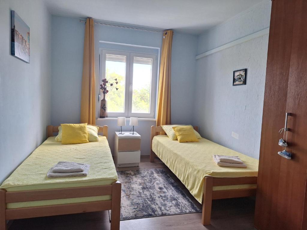 a bedroom with two beds and a window at Apartman Dejanović 2 in Veliko Gradište