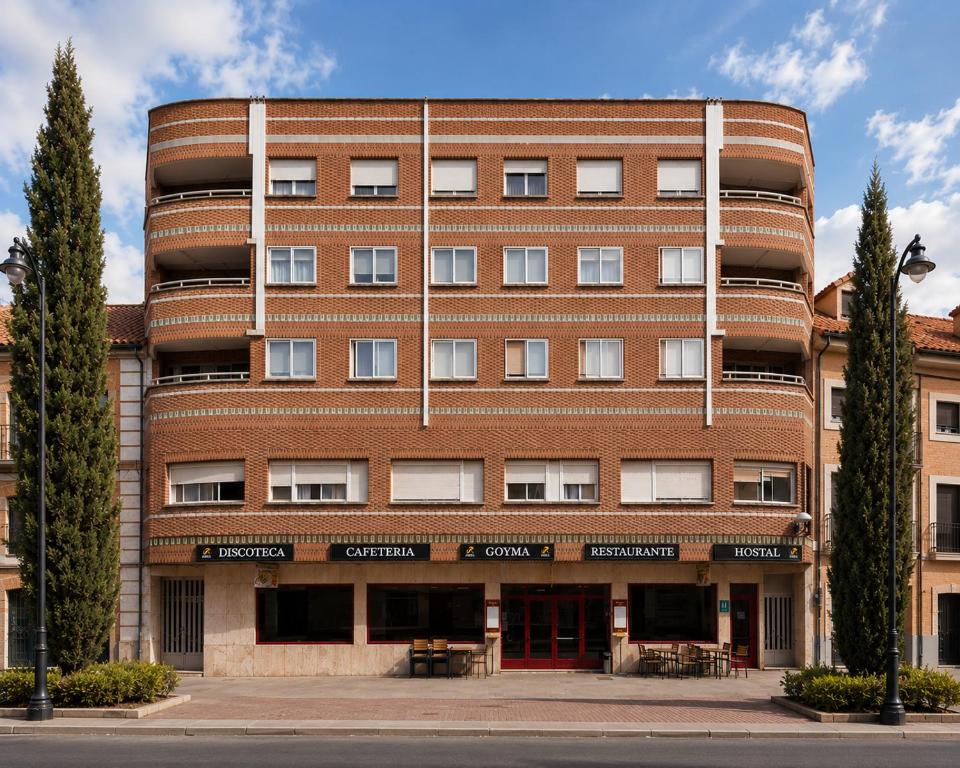 a red brick building with trees in front of it at Hostal Goyma I in San Fernando de Henares