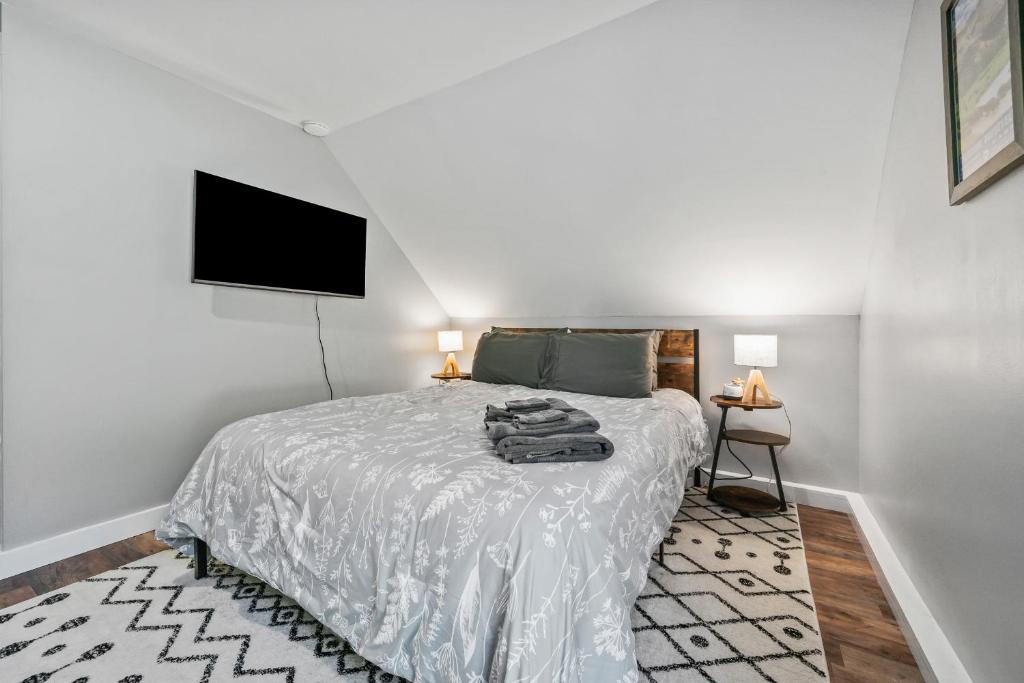 a bedroom with a bed and a flat screen tv at Cabot Modern Pet Friendly Apt 2nd Floor Studio in Whitefield