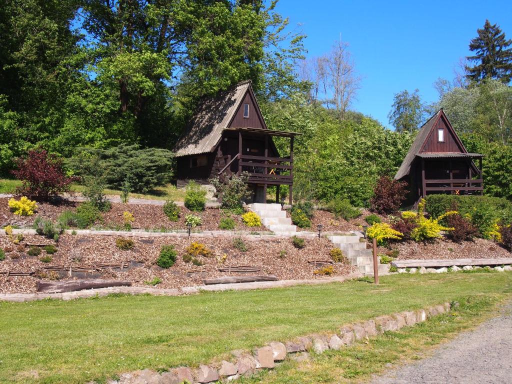 a garden with two thatched cottages at Kemp Prachovská osma in Libuň