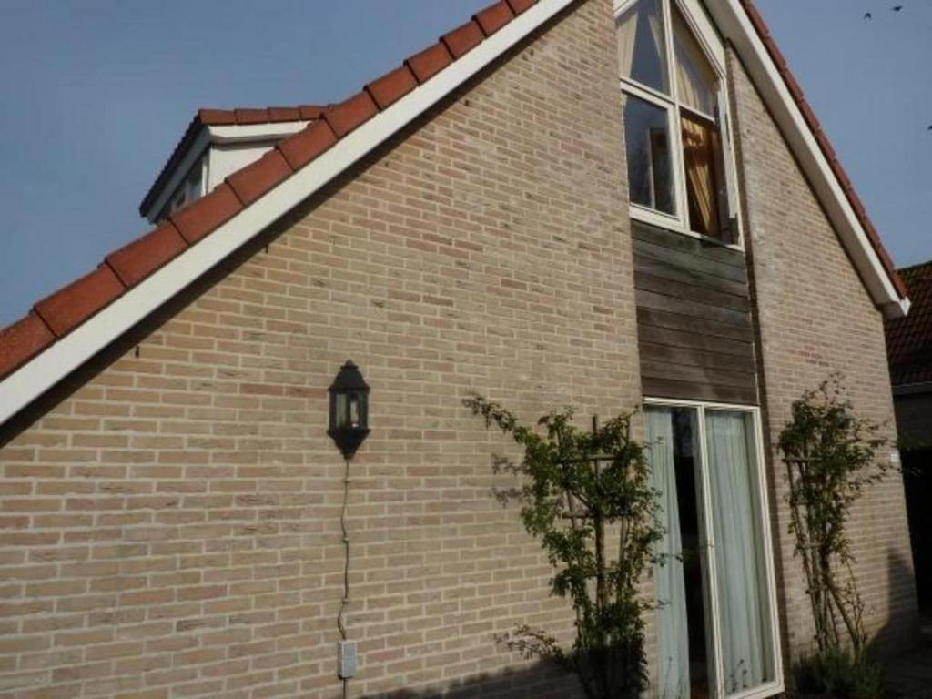 a brick house with a light on the side of it at Bungalow in Breskens near Beach & Lighthouse in Breskens
