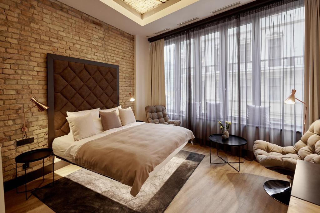 a bedroom with a large bed and a brick wall at The Loft Budapest in Budapest