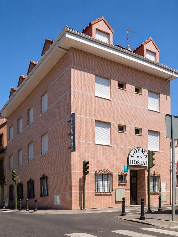 a large brick building with a clock on it at Hostal Goyma II in San Fernando de Henares
