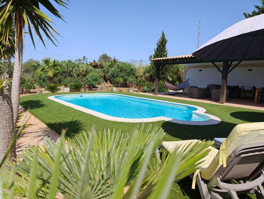 a swimming pool in the yard of a house at Quinta das Lameiras in Lagoa