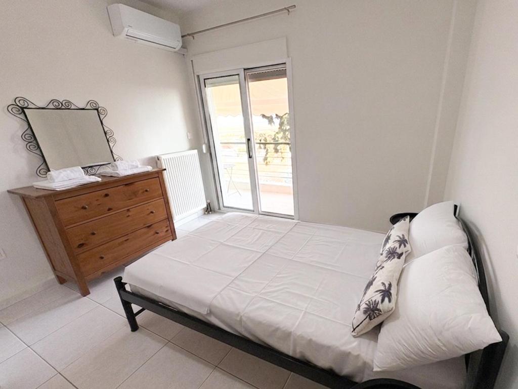 a bedroom with a bed and a dresser and a window at Alexandros House in Néa Tríglia