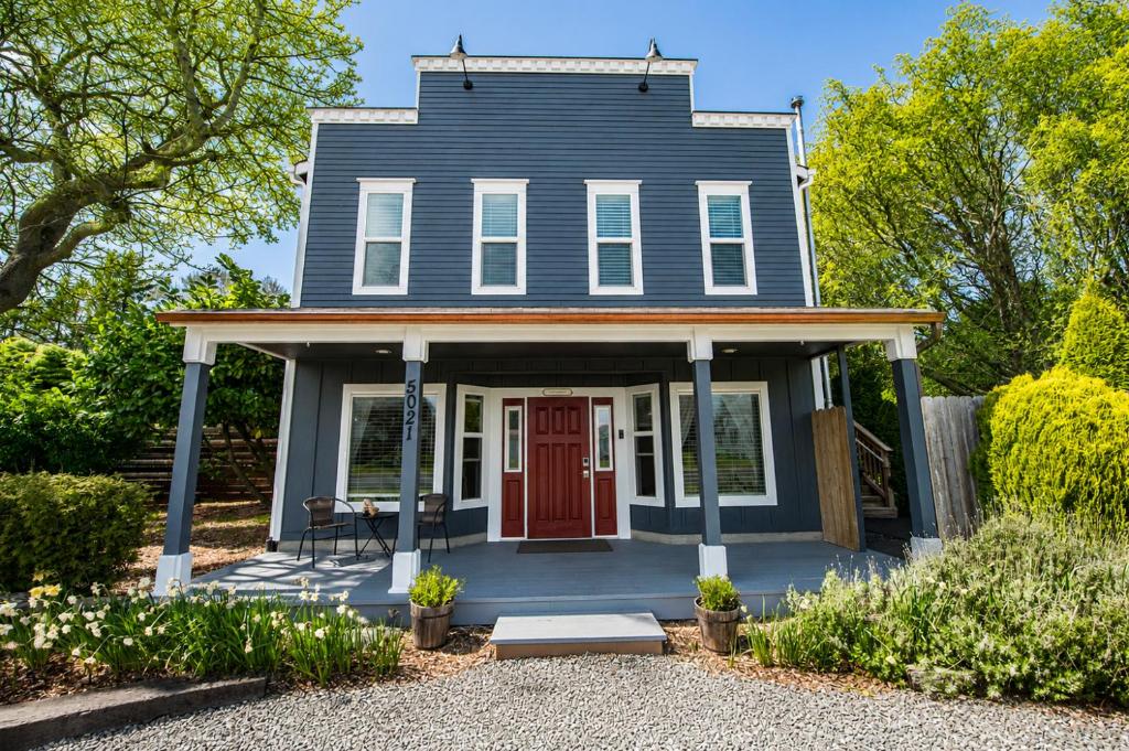 a blue house with a red door at Seaside Saloon Hot Tub Getaway in Sequim