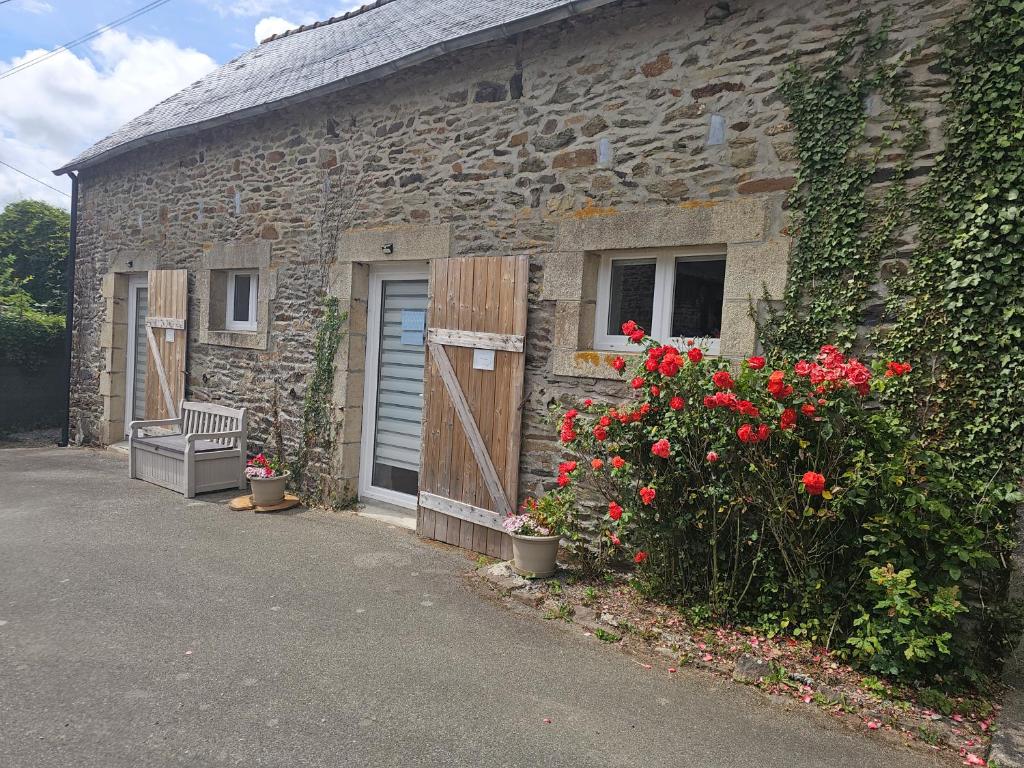 a stone building with a door and flowers in front of it at Les Marronniers Roses in Châteaulin