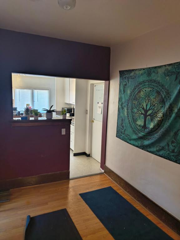 a living room with a painting of a tree on the wall at Briugu's Bunkhouse in Denver