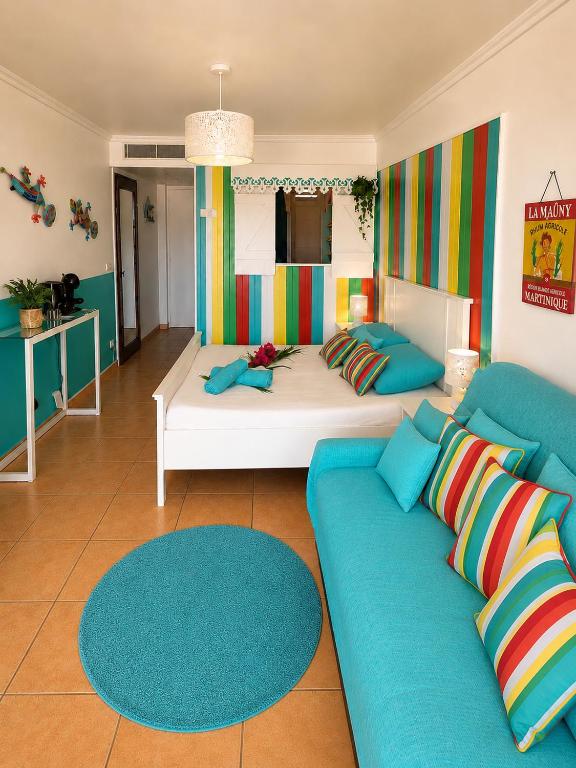 a living room with a couch and a bed at Couleur caraïbes-Ti créole appartement hotel club accès plage et piscine in Sainte-Luce