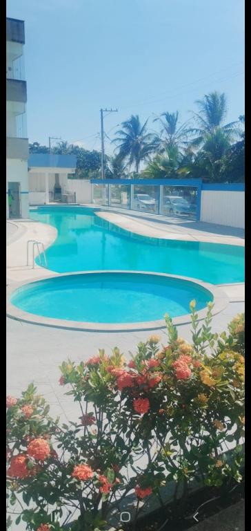 a swimming pool with blue water in a building at COBERTURA Duplex 302,vista d Mar e piscina in Piúma