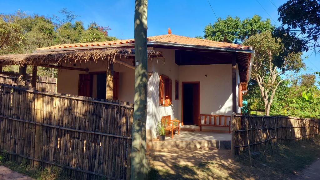 a small house with a wooden fence in front of it at Casa Rústica Próxima a Milho Verde, 3 QUARTOS - São Gonçalo do Rio das Pedras, Serro in Sêrro