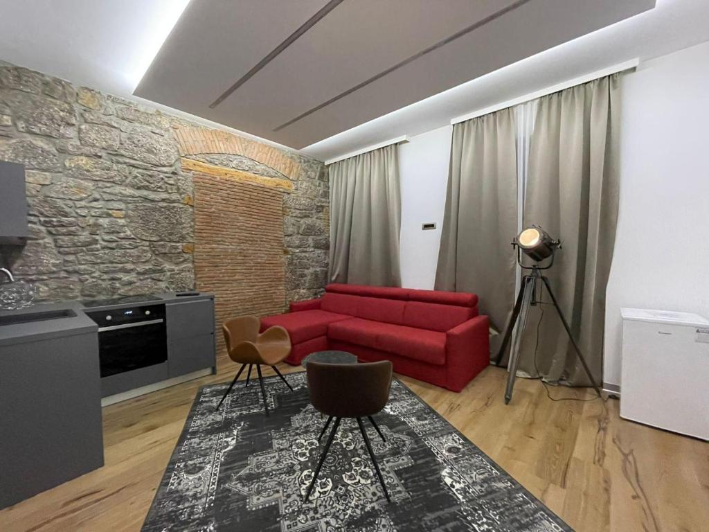 a living room with a red couch and a brick wall at Luxury Marina apartments in Rijeka