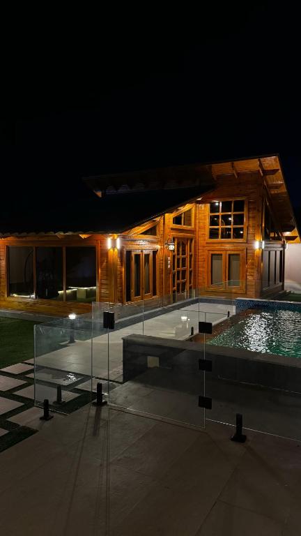 a house with a swimming pool at night at كوخ بحانز الأول in Taif