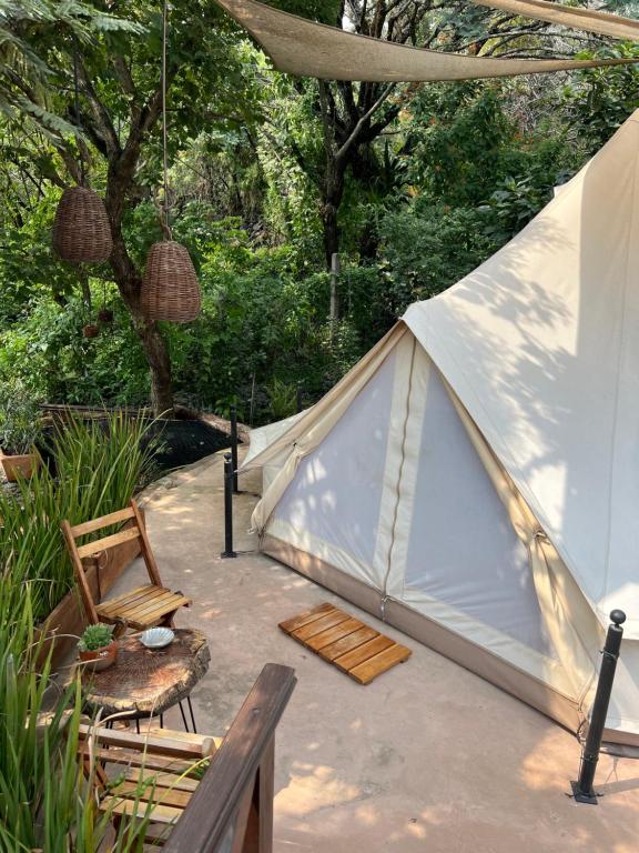 a tent with a table and chairs in a yard at Glamping en Casa Viento in Tepoztlán