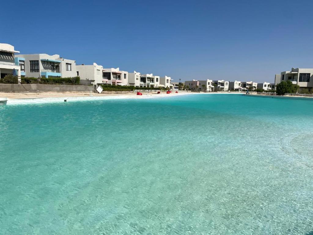 a large body of water with buildings in the background at Plage Mountain View in El Alamein
