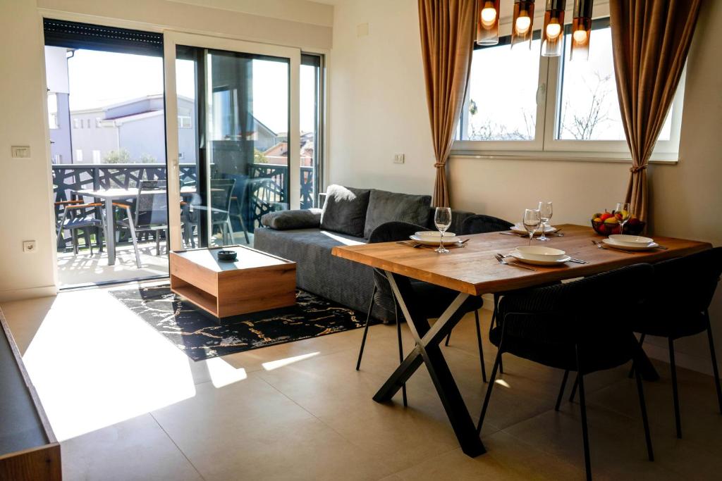 a living room with a table and a couch at Luxury Apartment Mara in Sukošan