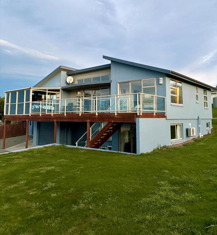 a large house with a deck on a lawn at Ocean view on Semple in Kakanui