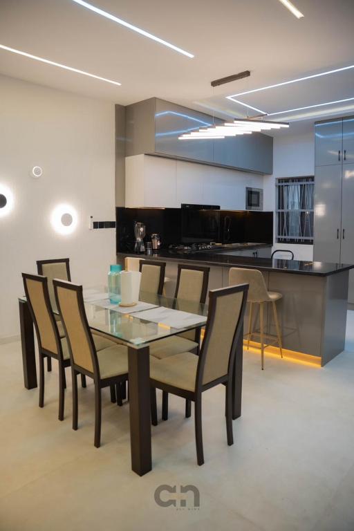 a dining room with a table and chairs and a kitchen at Villa BOCANIA in Cotonou