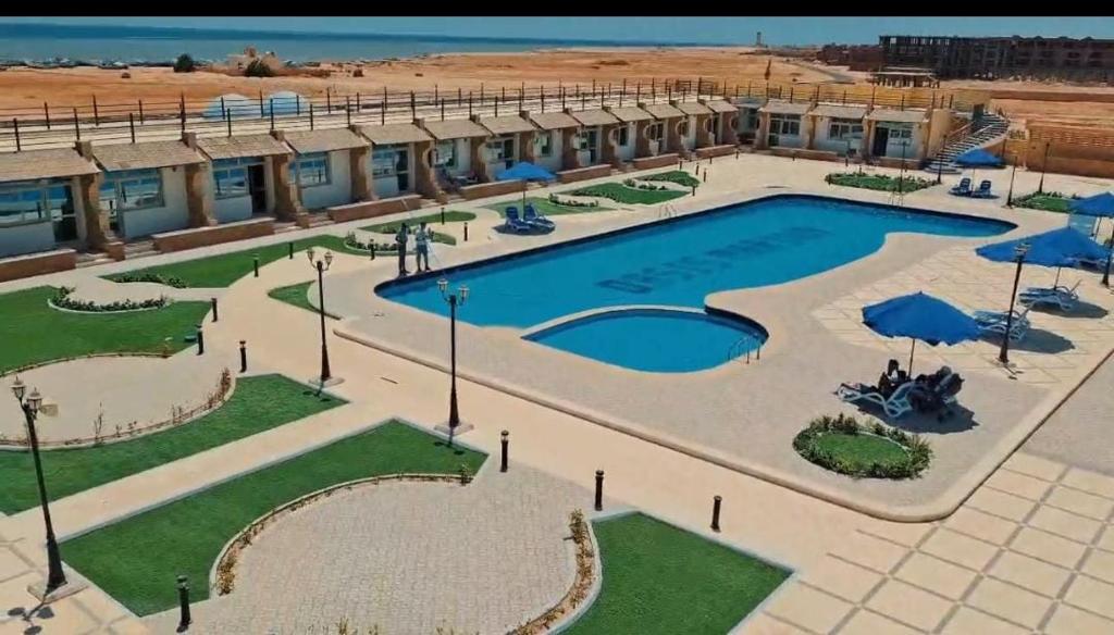 a large swimming pool with umbrellas and a building at اوسس مارينا in `Ezbet Bûgti