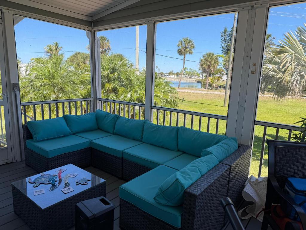 a screened in porch with a couch and a table at Tami Beach Resort Rental in Fort Myers Beach