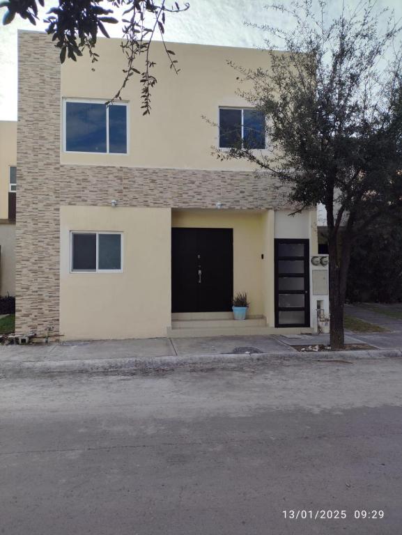 a white house with a black garage at casa confortabla y relajante con alberca y laguna in Monterrey