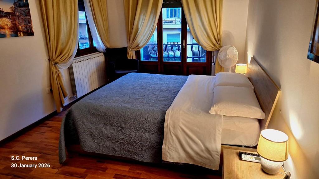 a bedroom with a bed and two windows at Venice Suites in Mestre