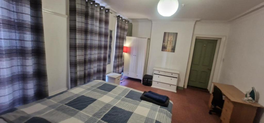 a bedroom with a bed and a desk and a dresser at King Suite in Ipswich