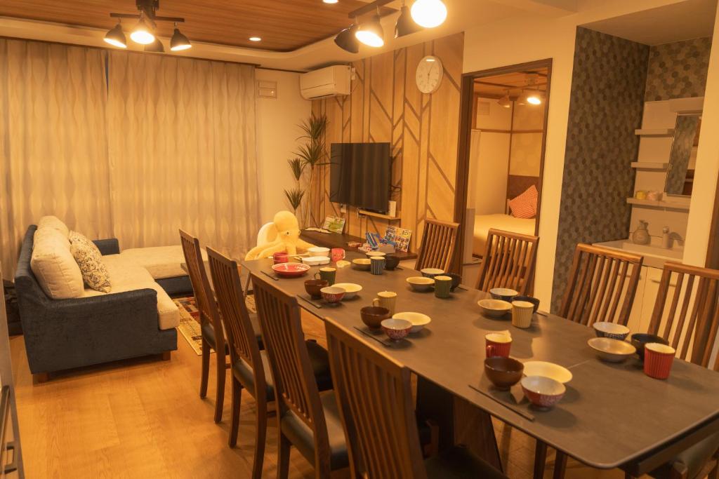 a living room with a table with chairs and a couch at New 充実設備&コスパ&快適重視の宿!空港美瑛富良野スキー場4ヵ所アクセス良!キッズエリア大人気 in Asahikawa