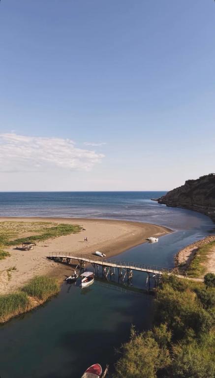 a pier on a beach with boats in the water at Ulcinj apartments in Ulcinj