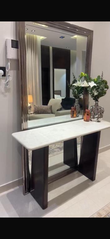 a table in a room with a large mirror at شقة غادة الفندقية الفاخرة in Abha